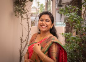 A joyful woman in a colorful saree posing outdoors, capturing cultural elegance.